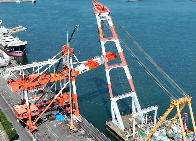 吊り上げた新しいブームを海岸クレーンに取り付けている様子