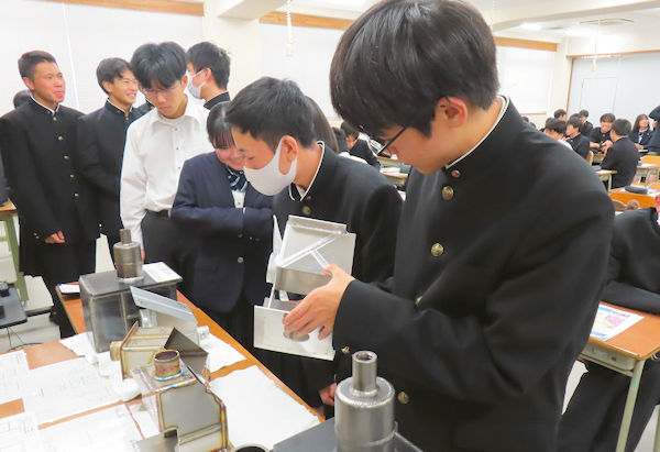 技能五輪全国大会の課題作品を手に取る生徒